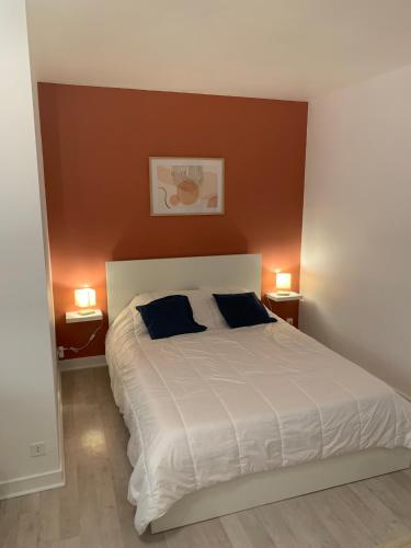 une chambre avec un grand lit blanc avec deux oreillers dans l'établissement Studio 27m² - centre-ville - parking privé - Tt équipée - 1km Gare TGV, au Pouliguen