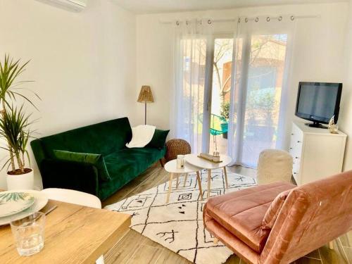 - un salon avec un canapé vert et une télévision dans l'établissement Eucalyptus Villa 29, à Argelès-sur-Mer