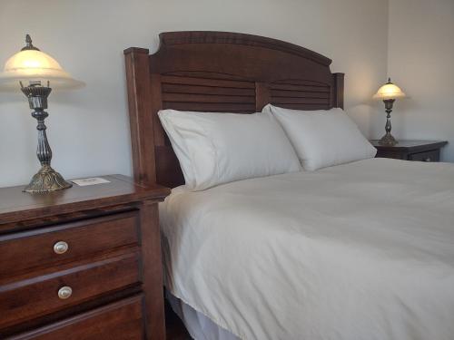 ein Schlafzimmer mit einem Bett und einem Nachttisch mit zwei Lampen in der Unterkunft Chez Rose Belaid in Perce