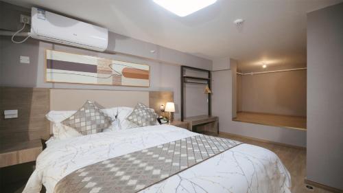 a bedroom with a large bed and a flat screen tv at Serveyou International Apartment Hotel - Free Airport Pickup & Free Canton Fair shuttle & Paid City Tour in Zengcheng