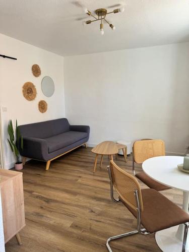 a living room with a blue couch and a table at Appartement centre historique in Narbonne