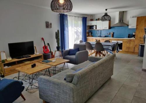 - un salon avec un canapé et une télévision dans l'établissement Chez Nini et Didi 10 pers proche plage au calme, à Andernos-les-Bains