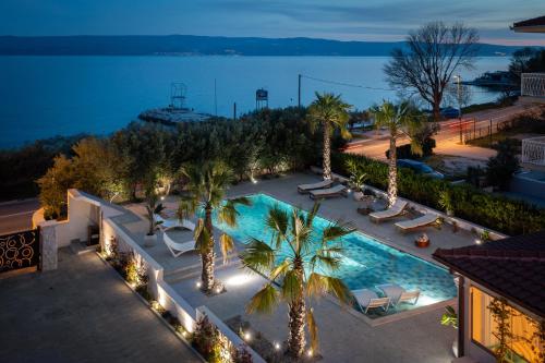 an overhead view of a swimming pool with palm trees at New Luxury Beach Villa in Duće
