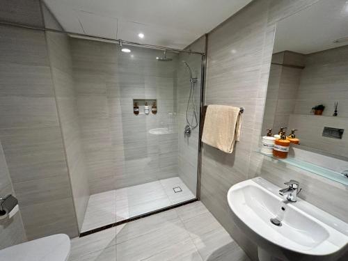 ein Bad mit einer Dusche und einem Waschbecken in der Unterkunft Luxury Romantic Sea View Apartment. in Manama