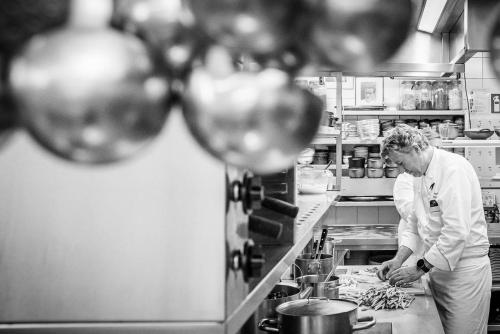 a man standing in a kitchen preparing food at Hotel Geerts in Westerlo