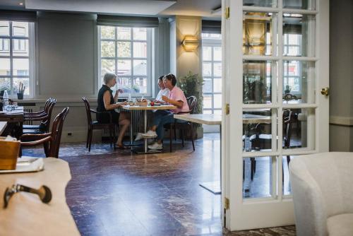 two people sitting at tables in a restaurant at Hotel Geerts in Westerlo