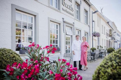a man and a woman standing in front of a building at Hotel Geerts in Westerlo