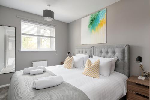 ein Schlafzimmer mit einem großen weißen Bett mit Kissen in der Unterkunft City Stay Apartments - Geldonia Court Bedford in Bedford
