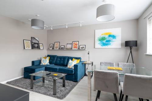 a living room with a blue couch and a table at City Stay Apartments - Geldonia Court Bedford in Bedford