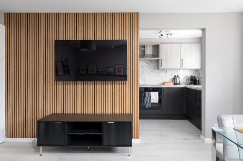 a living room with a television on a wall at City Stay Apartments - Geldonia Court Bedford in Bedford