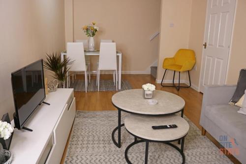uma sala de estar com um sofá, uma mesa e uma televisão em On Site Stays - Cosy ground floor 2 bed with Wifi and lots of Parking em Colchester