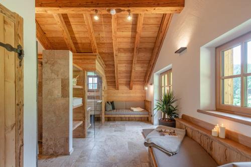 a large room with a wooden ceiling and a bedroom at Almchalet Linharterhof in Haus im Ennstal