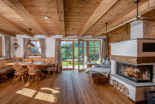 a living room with a fireplace and a table and chairs at Almchalet Linharterhof in Haus im Ennstal