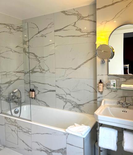 a bathroom with a bath tub and a sink at Hôtel Gabriel Paris in Paris