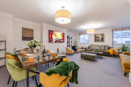 ein Wohnzimmer mit einem Tisch und gelben Stühlen in der Unterkunft Modern London Luxury 3Bedroom, 3Bathroom Retreat 6 in London