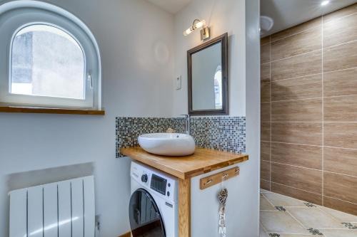 La salle de bains est pourvue d'un lavabo et d'un lave-linge. dans l'établissement Les bois flottés, à Poussan