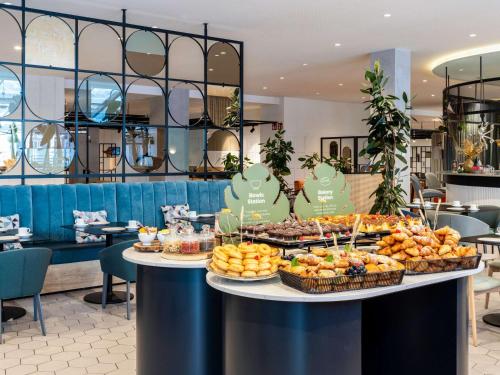 a buffet of food on a table in a restaurant at Novotel Campo De Las Naciones in Madrid