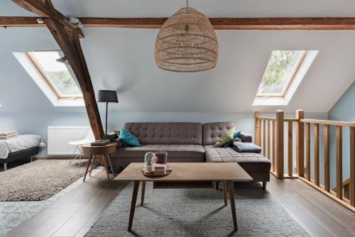 ein Wohnzimmer mit einem Sofa und einem Tisch in der Unterkunft Van Hamme 1642 - house for 2 to 4 persons in Kortenberg