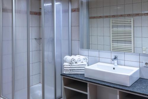 La salle de bains blanche est pourvue d'un lavabo et d'une douche. dans l'établissement Ferienwohnungen Reiter, à Flachau