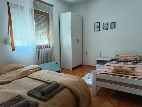 a bedroom with two beds with towels on them at Apartman Natura vita Blagaj in Blagaj