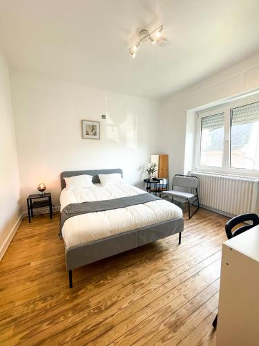 um quarto com uma cama grande e piso em madeira em Berchem - Guest House em Bonnevoie