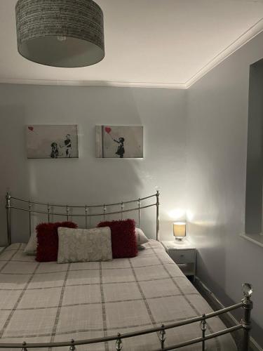 a bedroom with a bed with red pillows on it at Lovely 1 Bedroom Ground floor apartment max 4 per in Hythe