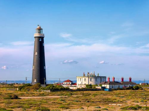 a lighthouse sitting on top of a grass covered field at Lovely 1 Bedroom Ground floor apartment max 4 per in Hythe