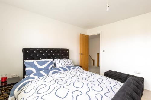 a bedroom with a bed with a black and white comforter at Supreme Class Properties in Eastchurch