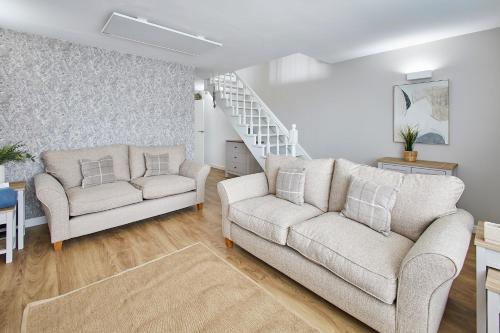 a living room with two couches and a staircase at Host & Stay - Emilyn House in Whitburn