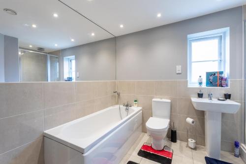 ein Badezimmer mit einer Badewanne, einem WC und einem Waschbecken in der Unterkunft Supreme Class Properties in Eastchurch