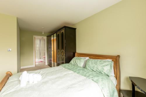 a bedroom with a large white bed with green sheets at Supreme Class Properties in Eastchurch