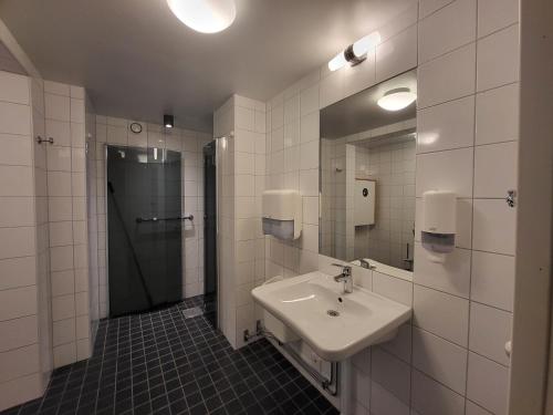 a bathroom with a sink and a shower and a mirror at STF Kapellskär Hostel in Gräddö