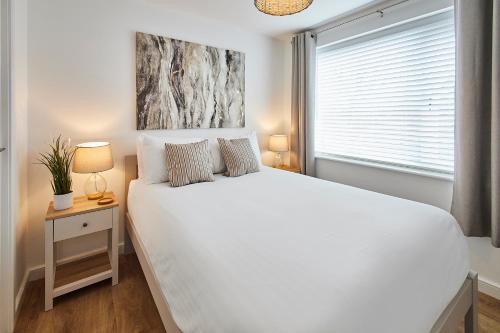 a bedroom with a large white bed and a window at Host & Stay - Emilyn House in Whitburn