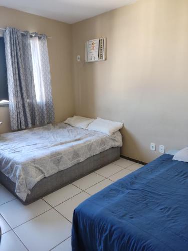 a small bedroom with a bed and a window at Recanto Junto a Praia in Aracaju