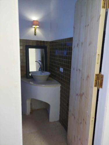 ein Bad mit einem Waschbecken und einem Spiegel in der Unterkunft El baladi in Abu Simbel