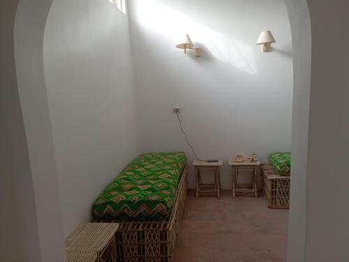 Zimmer mit einem Bett und einem Tisch mit einer Lampe in der Unterkunft El baladi in Abu Simbel