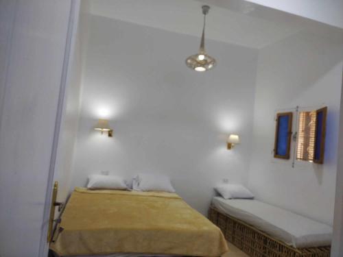 a bedroom with two beds in a white wall at El baladi in Abu Simbel