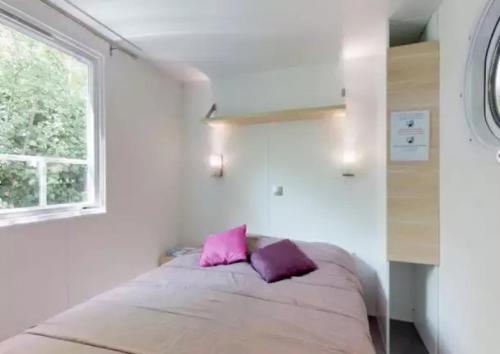a bedroom with a bed with a pink pillow at Mobilhome 3 étoiles - eec0cf in L'Isle-sur-la-Sorgue