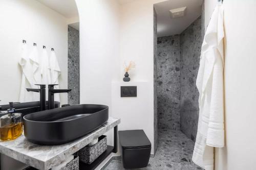 ein Bad mit einer schwarzen Badewanne und einem Waschbecken in der Unterkunft apart33 - Alpendorf in Salzburg in St. Johann im Pongau