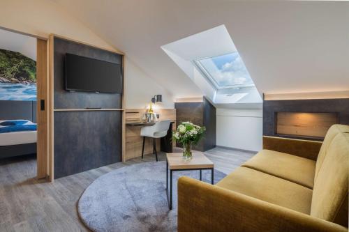 uma sala de estar com um sofá e uma cama em Best Western Hotel München Airport em Erding