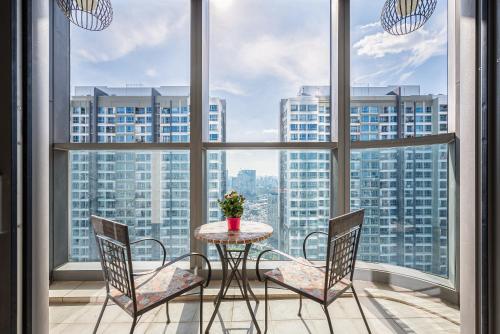 uma mesa e cadeiras num quarto com janelas grandes em Isabelle Luxury Apartment inside Landmark 81 Tower em Ho Chi Minh