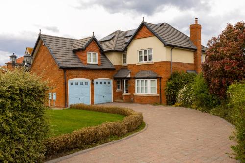 a brick house with two garages and a driveway at Supreme Class Properties in Eastchurch