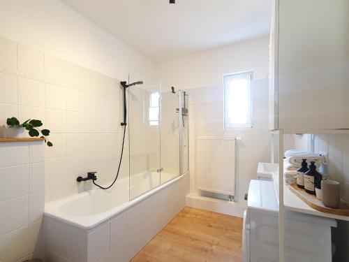 bagno bianco con doccia e vasca di Moderne 2-Zimmer-Wohnung in Gohlis, Leipzig a Lipsia