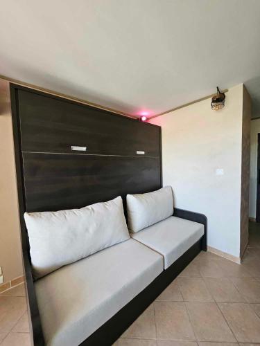 - un canapé avec deux oreillers dans l'établissement Studio Calista - Quartier Naturiste Cap d'Agde, au Cap d'Agde