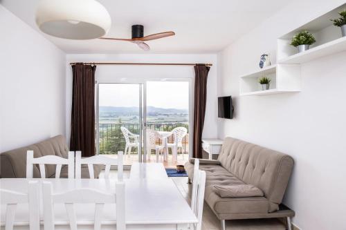 sala de estar con mesa blanca y sillas en Apartamentos Torrevella, en L'Estartit