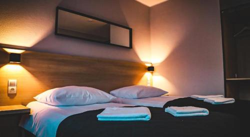 a bedroom with a bed with two towels on it at Hotel Bastion in Malbork