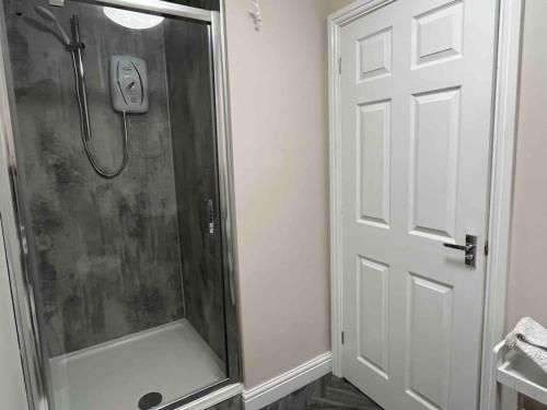 a shower stall in a bathroom with a door at The Print Room, 1 Bedroom Ground Floor Apartment in Carlisle