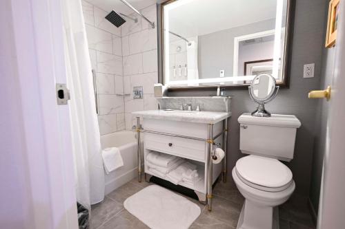a bathroom with a sink and a toilet and a mirror at Hotel Roanoke & Conference Center, Curio Collection by Hilton in Roanoke