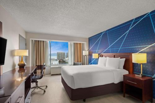 a hotel room with a bed and a desk and a window at Comfort Inn By the Bay in San Francisco