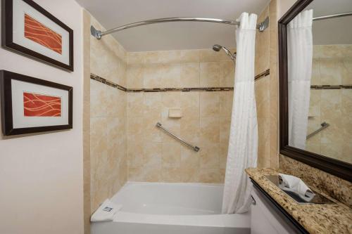 a bathroom with a tub and a shower and a sink at Comfort Inn Oceanside Deerfield Beach in Deerfield Beach